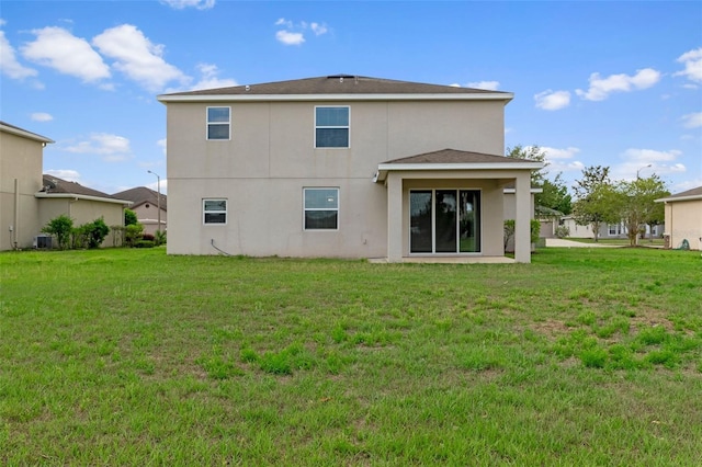 13619 Hunters Point St, Spring Hill, FL 34609 - back of house featuring a yard, central AC, and stucco siding