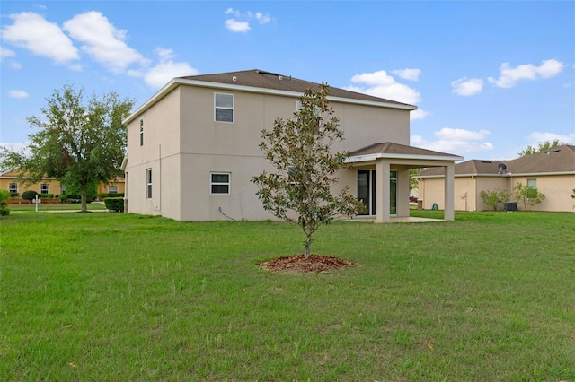 13619 Hunters Point St, Spring Hill, FL 34609 - back of house with a patio, a lawn, and stucco siding