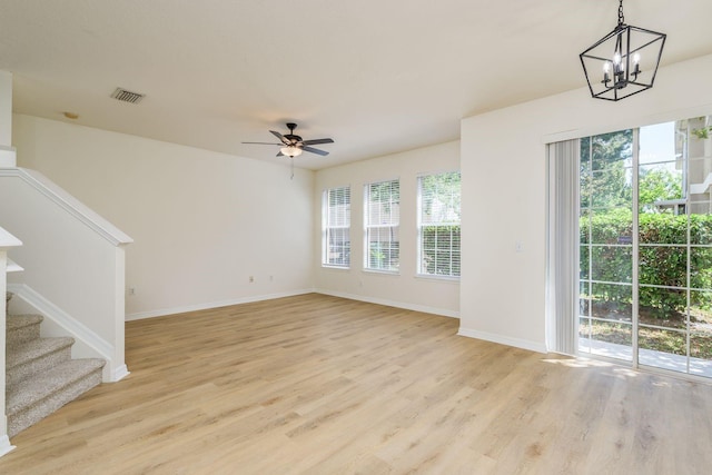 unfurnished living room featuring healthy amount of natural light, light wood finished floors, and baseboards