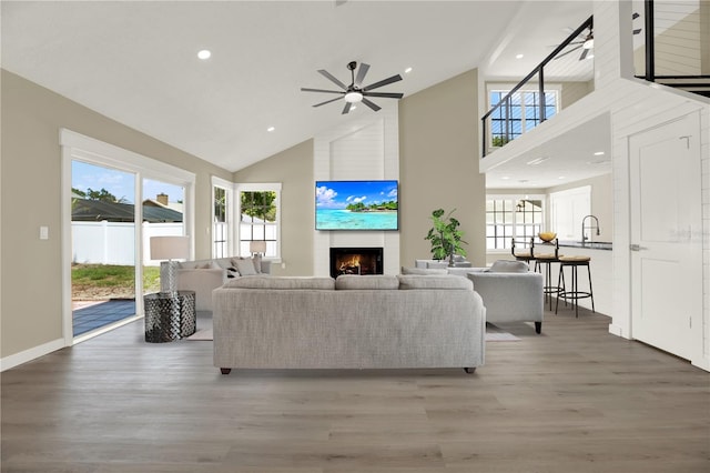 10423 Ashley Oaks Dr, Riverview, FL 33578 - living area with baseboards, wood finished floors, a large fireplace, ceiling fan, and high vaulted ceiling