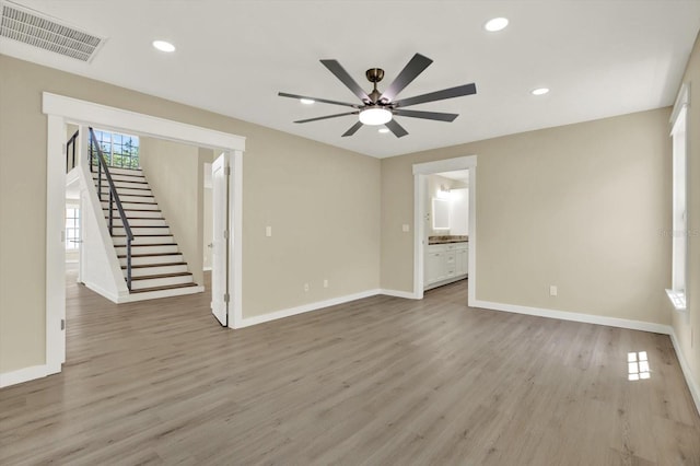 10423 Ashley Oaks Dr, Riverview, FL 33578 - unfurnished living room featuring baseboards, visible vents, wood finished floors, ceiling fan, and stairway