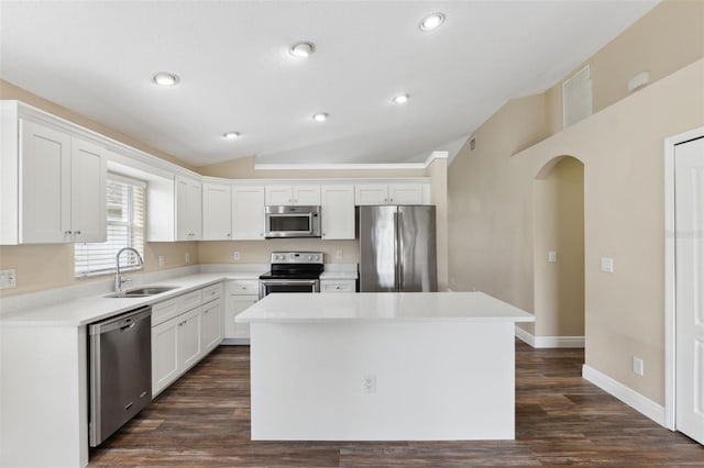 kitchen featuring white cabinetry, a center island, a sink, lofted ceiling, and stainless steel appliances