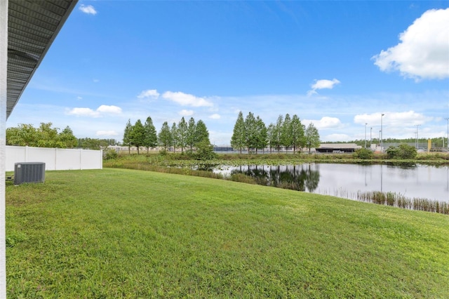 view of yard featuring a water view, fence, and cooling unit