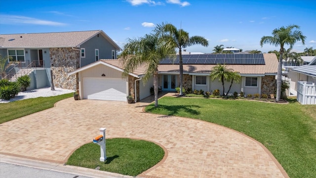 5033 Cabrilla Ct, New Port Richey, FL 34652 - single story home featuring stone siding, decorative driveway, solar panels, an attached garage, and a tile roof