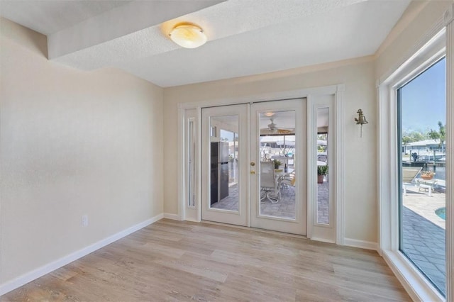5033 Cabrilla Ct, New Port Richey, FL 34652 - spare room featuring french doors, light wood-type flooring, and a textured ceiling