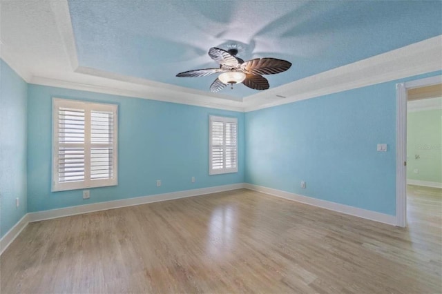 5033 Cabrilla Ct, New Port Richey, FL 34652 - unfurnished room with a raised ceiling, crown molding, a textured ceiling, ceiling fan, and light wood-type flooring