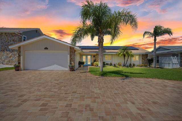 5033 Cabrilla Ct, New Port Richey, FL 34652 - view of front of property featuring french doors, stone siding, a lawn, a garage, and decorative driveway
