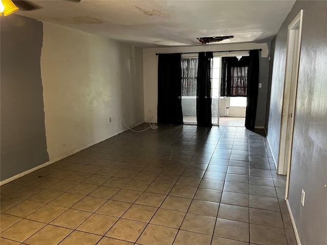 unfurnished room featuring baseboards and light tile patterned floors