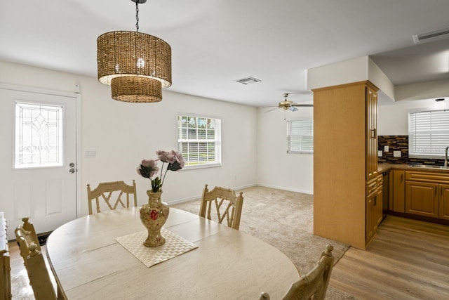 dining area featuring visible vents, a ceiling fan, and baseboards