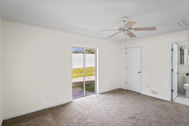 unfurnished bedroom with carpet floors, visible vents, access to exterior, attic access, and ensuite bath