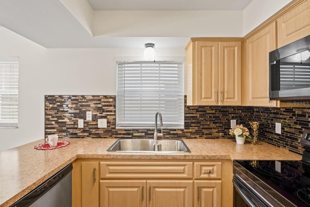 kitchen featuring decorative backsplash, light brown cabinets, light countertops, a sink, and appliances with stainless steel finishes