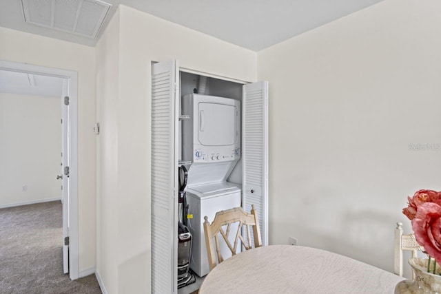 laundry area featuring laundry area, attic access, visible vents, stacked washing maching and dryer, and carpet