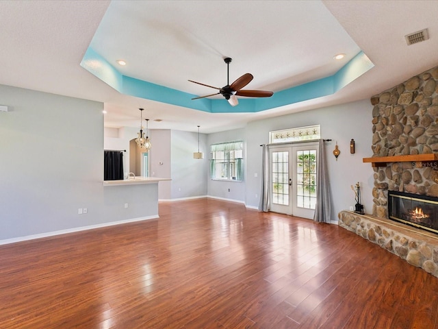 10318 Piper Dr, New Port Richey, FL 34654 - unfurnished living room with visible vents, ceiling fan, wood finished floors, and a fireplace