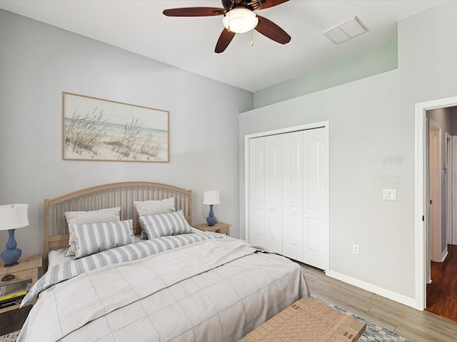 10318 Piper Dr, New Port Richey, FL 34654 - bedroom featuring wood finished floors, a closet, baseboards, visible vents, and a ceiling fan