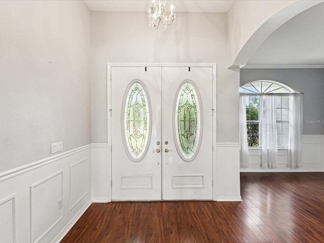 10318 Piper Dr, New Port Richey, FL 34654 - foyer featuring wainscoting, arched walkways, wood finished floors, and a decorative wall