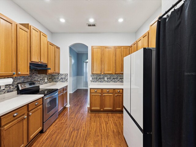 10318 Piper Dr, New Port Richey, FL 34654 - kitchen with stainless steel electric range oven, visible vents, freestanding refrigerator, arched walkways, and dark wood-type flooring