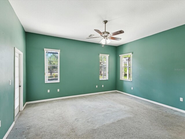 10318 Piper Dr, New Port Richey, FL 34654 - carpeted empty room featuring baseboards, a ceiling fan, and a wealth of natural light