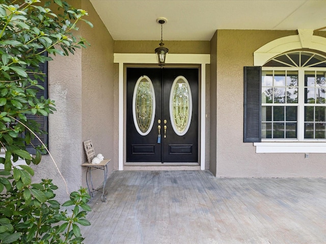 10318 Piper Dr, New Port Richey, FL 34654 - view of exterior entry with stucco siding, a porch, and french doors