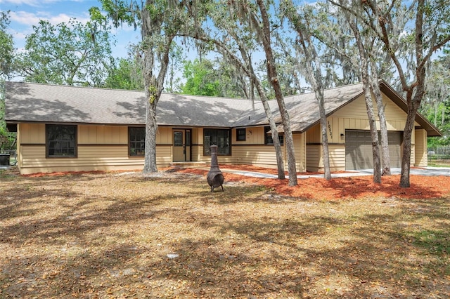 single story home with a garage and a shingled roof