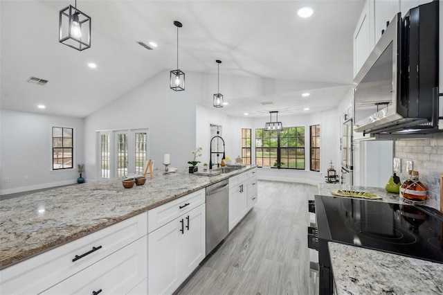 kitchen with white cabinets, visible vents, light stone counters, a sink, and stainless steel appliances