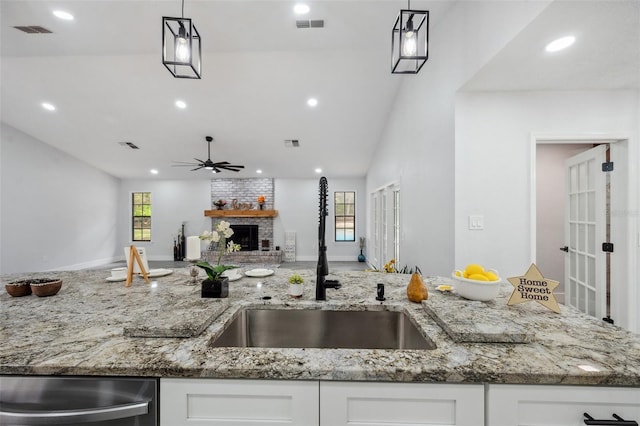 kitchen featuring ceiling fan, a sink, white cabinetry, and visible vents