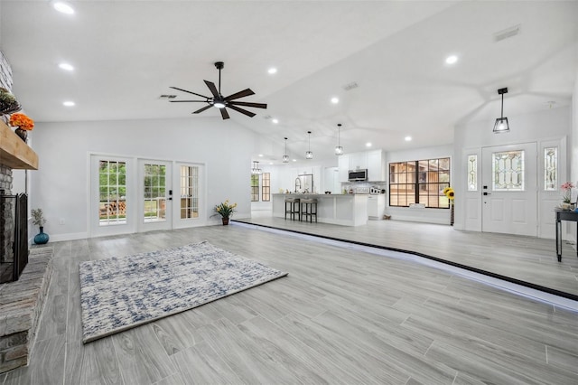living area with plenty of natural light, visible vents, ceiling fan, and lofted ceiling