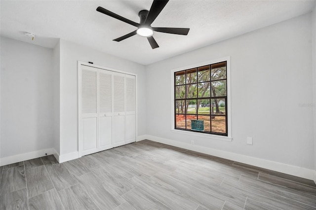 unfurnished bedroom with a closet, ceiling fan, and baseboards