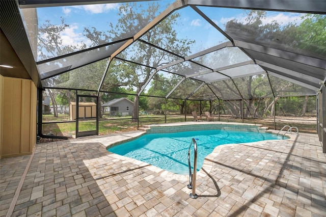 pool featuring a lanai, an outdoor structure, a patio, and a storage unit