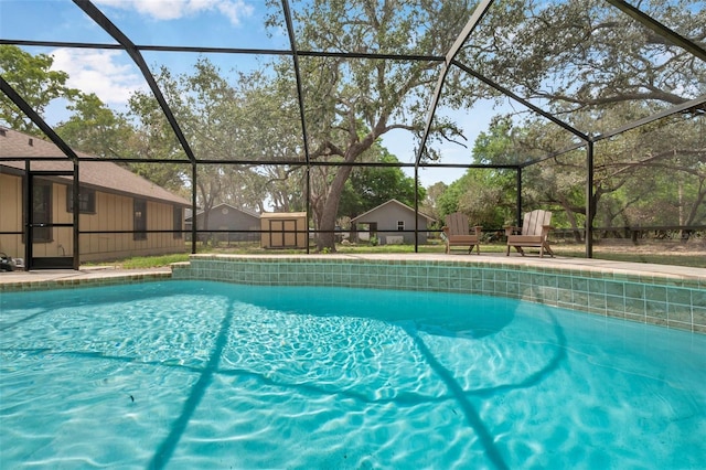 pool with an outbuilding, a patio, and a lanai