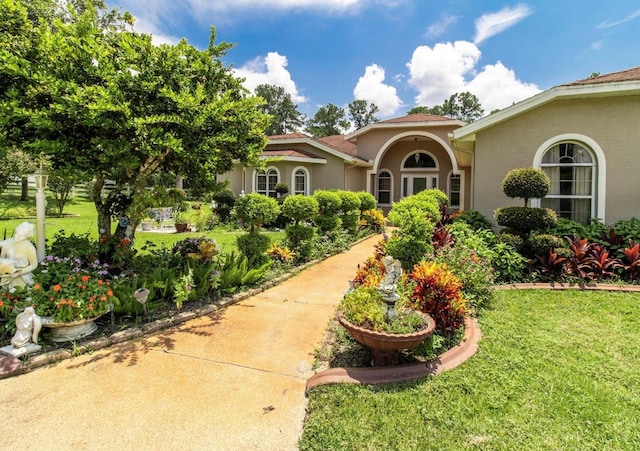 mediterranean / spanish-style home featuring a front lawn and stucco siding