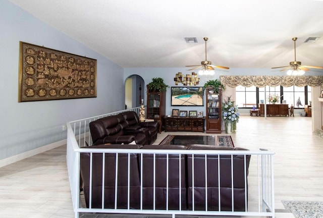 living room with visible vents, ceiling fan, and arched walkways