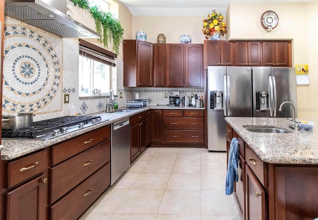 kitchen featuring a sink, tasteful backsplash, appliances with stainless steel finishes, and wall chimney exhaust hood