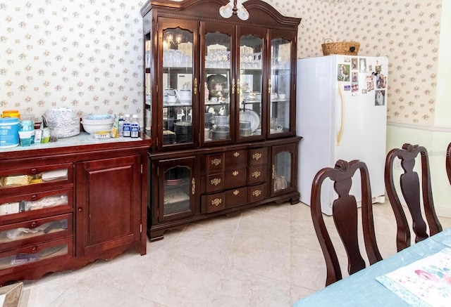 dining space featuring wallpapered walls and light tile patterned floors