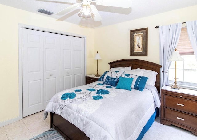 bedroom featuring visible vents, ceiling fan, a closet, and light tile patterned floors