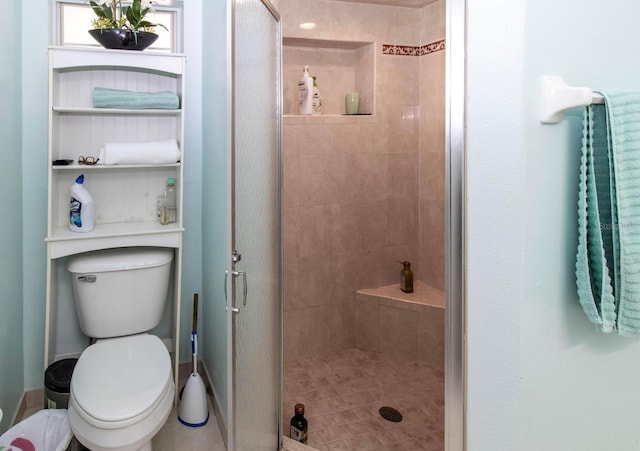 bathroom with a shower stall and toilet