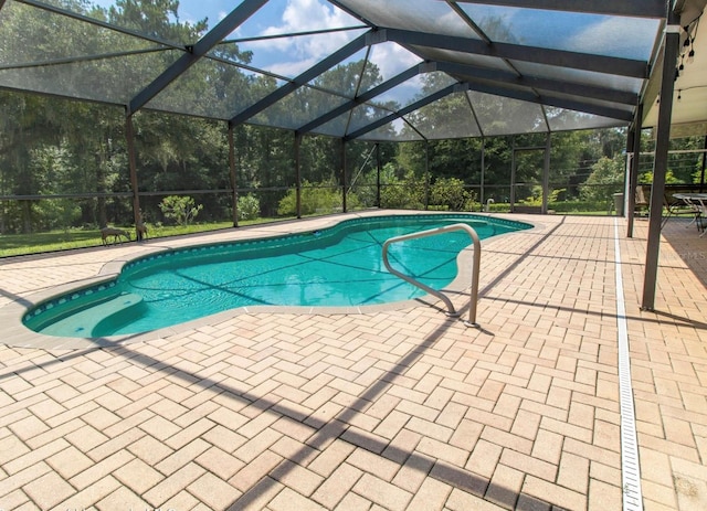 outdoor pool featuring a patio and glass enclosure