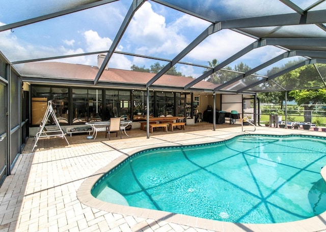 pool featuring glass enclosure and a patio
