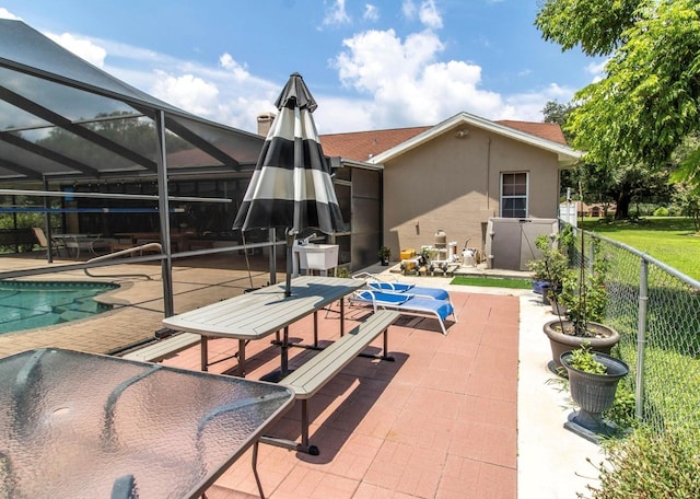 view of pool featuring a patio, a fenced in pool, fence, and glass enclosure