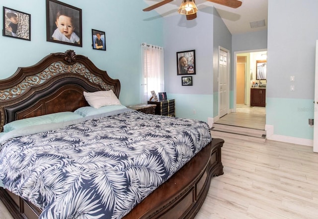 bedroom featuring light wood-style flooring, a ceiling fan, visible vents, lofted ceiling, and baseboards