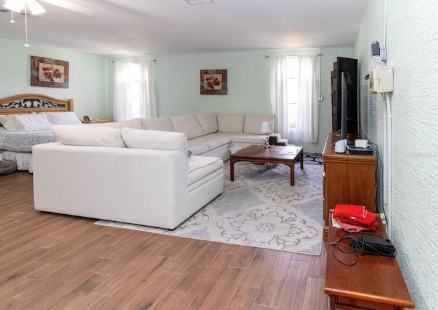 living room featuring a wealth of natural light, a ceiling fan, and light wood-style floors