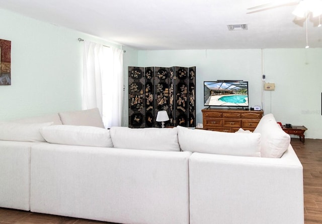 living area featuring wood finished floors, ceiling fan, and visible vents