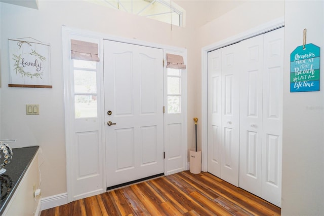 foyer with dark wood-type flooring and baseboards