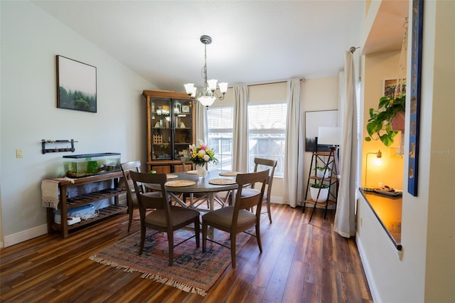 dining area featuring dark wood-type flooring, baseboards, and a chandelier