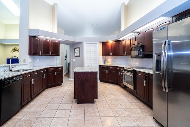 kitchen featuring a sink, decorative backsplash, black appliances, and a kitchen island