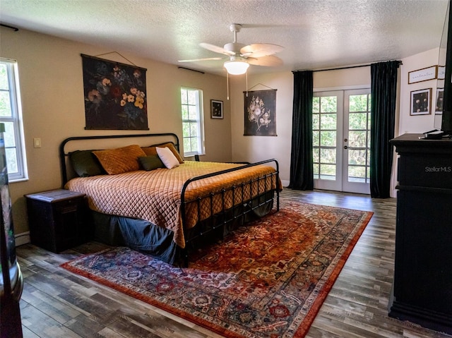 bedroom with access to outside, multiple windows, a textured ceiling, and french doors