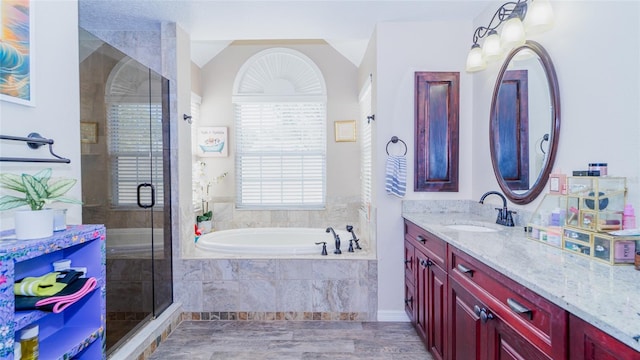 full bathroom featuring a bath, vanity, and a stall shower