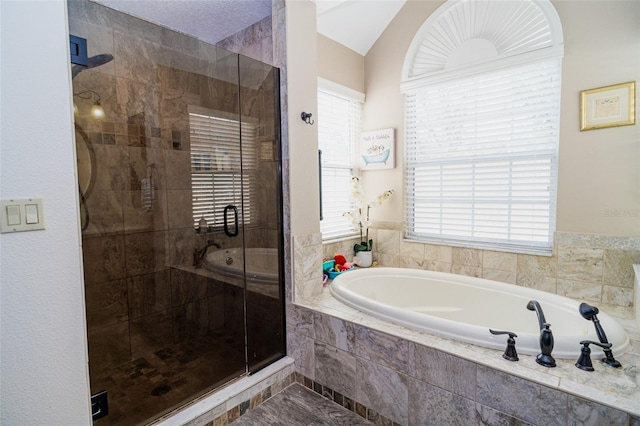 bathroom featuring a bath, vaulted ceiling, and a stall shower