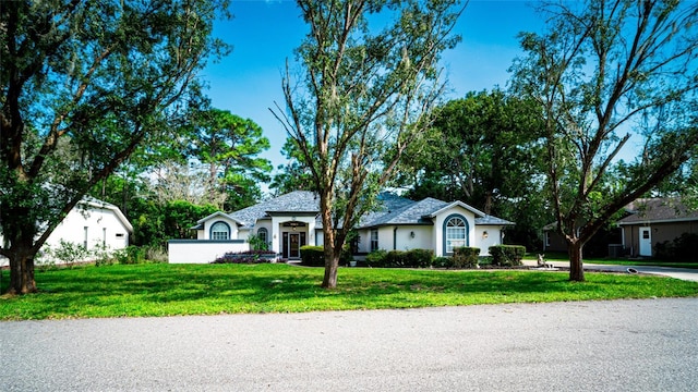 single story home featuring a front lawn and stucco siding