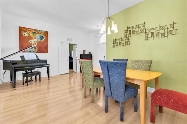 6109 Japonica Ct, New Port Richey, FL 34655 - dining space featuring light wood finished floors, an inviting chandelier, baseboards, and visible vents