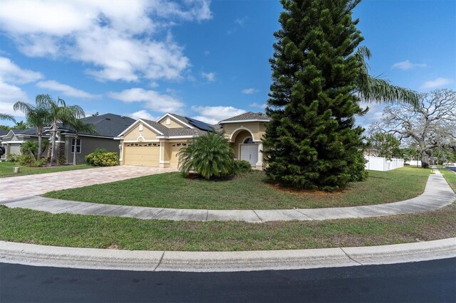 6109 Japonica Ct, New Port Richey, FL 34655 - view of front of home featuring a front yard, driveway, fence, and an attached garage